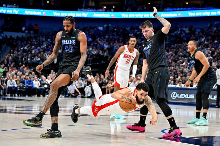 Rockets guard Fred VanVleet is tripped up in front of Dallas Mavericks forward Derrick Jones Jr. and guard Luka Doncic